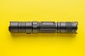 Metal led flashlight on yellow background, top view Royalty Free Stock Photo