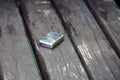 Metal lighter sitting on a bench in the park. Royalty Free Stock Photo