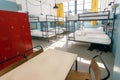 Metal locker, table and double-decker beds inside hostel room with tall windows Royalty Free Stock Photo