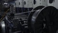 Metal long narrow sheets wraping on a bobbin. Creative. Large spool in a factory workshop, industrial background.