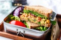 metal lunchbox with a vegan chickpea salad sandwich