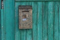 metal mailbox hanging on a green wooden fence in the street Royalty Free Stock Photo