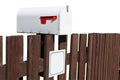 Metal mailbox mounted on a rustic fence isolated Royalty Free Stock Photo