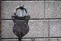 A metal mailbox in the shape of a huge padlock against a gray stone wall