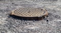 Metal manhole on the road when paving new asphalt. Renovation work. A closed hatch on the road poses no danger to pedestrians and