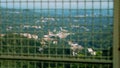 A metal mesh on a bridge, guarding against a precipice, serving as a barrier to prevent suicides, often linked to