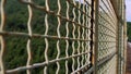 A metal mesh on a bridge, guarding against a precipice, serving as a barrier to prevent suicides, often linked to