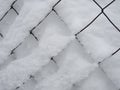 Metal mesh fence of a tennis court covered in snow Royalty Free Stock Photo