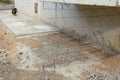 Metal mesh installed over sand and gravel. The process of repairing the blind area of the foundation of an apartment building