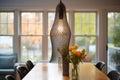 Metal mesh pendant light fixture above decorative vase