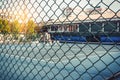 Metal mesh wire fence with tennis court in blurry for background Royalty Free Stock Photo