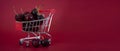 A metal mini supermarket cart filled with juicy red cherries on a bardic background. copy space Royalty Free Stock Photo