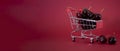 A metal mini supermarket cart filled with juicy red cherries on a bardic background. copy space Royalty Free Stock Photo