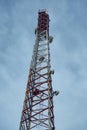 Metal mobile communications tower cell site with antennas close-up against the sky at dusk. Vertical orientation. Royalty Free Stock Photo