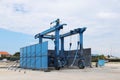 Metal mobile crane for launching small vessels and yachts. The iron structure is blue. Equipping of a seaport and a yacht marina.