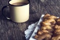 Metal mug full of coffee and a plate of koeksisters in artistic Royalty Free Stock Photo