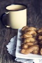 Metal mug full of coffee and a plate of koeksisters in artistic Royalty Free Stock Photo