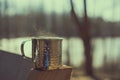 Metal mug holding hot liquid in woods Royalty Free Stock Photo