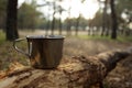 metal mug on a log in the forest.Tea or coffee time. The concept of hiking in the forest Royalty Free Stock Photo