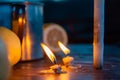 A metal mug of tea, lemon, apples and lighted candles on the wooden table a cold autumn day