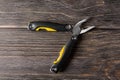 metal multi-tool with pliers on a wooden background. Royalty Free Stock Photo