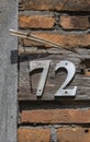 Metal numbers on piece of wood and brick background Royalty Free Stock Photo