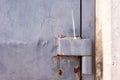 Metal old door or gate hinge located at the edge of cement door frame with crack and rusty color painting surface. Concept of