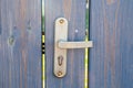 Metal old handle on the street fence of the door. A gray wooden fence with gaps between the boards. A sunbeam breaks through the Royalty Free Stock Photo