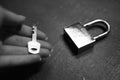 Metal open heavy lock on the table and female fingers with key