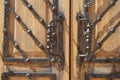 Metal original vintage wrought iron handle on an old wooden brown door with metal antique decor. Exterior decoration element Royalty Free Stock Photo