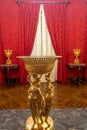 metal ornament against a background of the red curtains of the imperial room