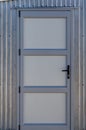 A metal panel door in a grey metal building Royalty Free Stock Photo