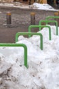 Metal parking lot for bicycles is covered with snow. Street parking. Street cleaning in winter Royalty Free Stock Photo