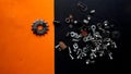 Metal parts on black and orange background. in the photo there are all kinds of pieces that are kept in a jar to use when needed