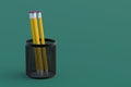 Metal pencil holder on green background. Grid pot. Copy space