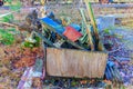 Metal pieces and bars stacked in wooden container in backyard