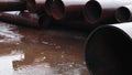 Metal pipes for gasification of large diameter lie on construction site in rain. Video.