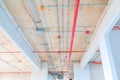 Metal pipes interior in Construction and fire sprinkler on red pipe are hanging from ceiling inside