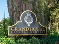 Metal plaque with the name of the Grand Hotel is installed near a large tree. Nuwara Eliya, Sri Lanka