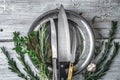 Metal plate with knifes and different herbs on the white table top view