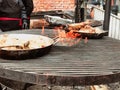 metal plates with pilaf and meat on the grill on an open fire