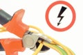 Metal pliers cut electric cable. High voltage danger sign in background. Technology concept Royalty Free Stock Photo