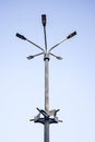 Metal pole with five modern LED lights set against clear blue sky. Street lighting. Bottom view. Copy space