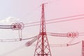 Metal poles of a power line with wires against a blue sky. Sunset landscape using toning