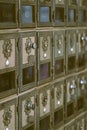 Side view of rows of aged brown metal post office mail boxes with silver alphabetic combination star locks and glass windows Royalty Free Stock Photo