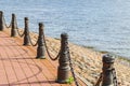 Metal posts with thick chain-link fencing on the embankment Royalty Free Stock Photo