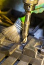 Metal Processing. Fitter Man Using Special Brush for Cleaning Metal Drilling Machine From Metal Shavings in Workshop Royalty Free Stock Photo