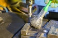 Metal Processing. Fitter Man Using Special Brush for Cleaning Metal Drilling Machine From Metal Shavings in Workshop Royalty Free Stock Photo