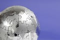 Metal puzzle globe on blue background Royalty Free Stock Photo