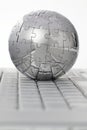 Metal puzzle globe on computer keyboard Royalty Free Stock Photo